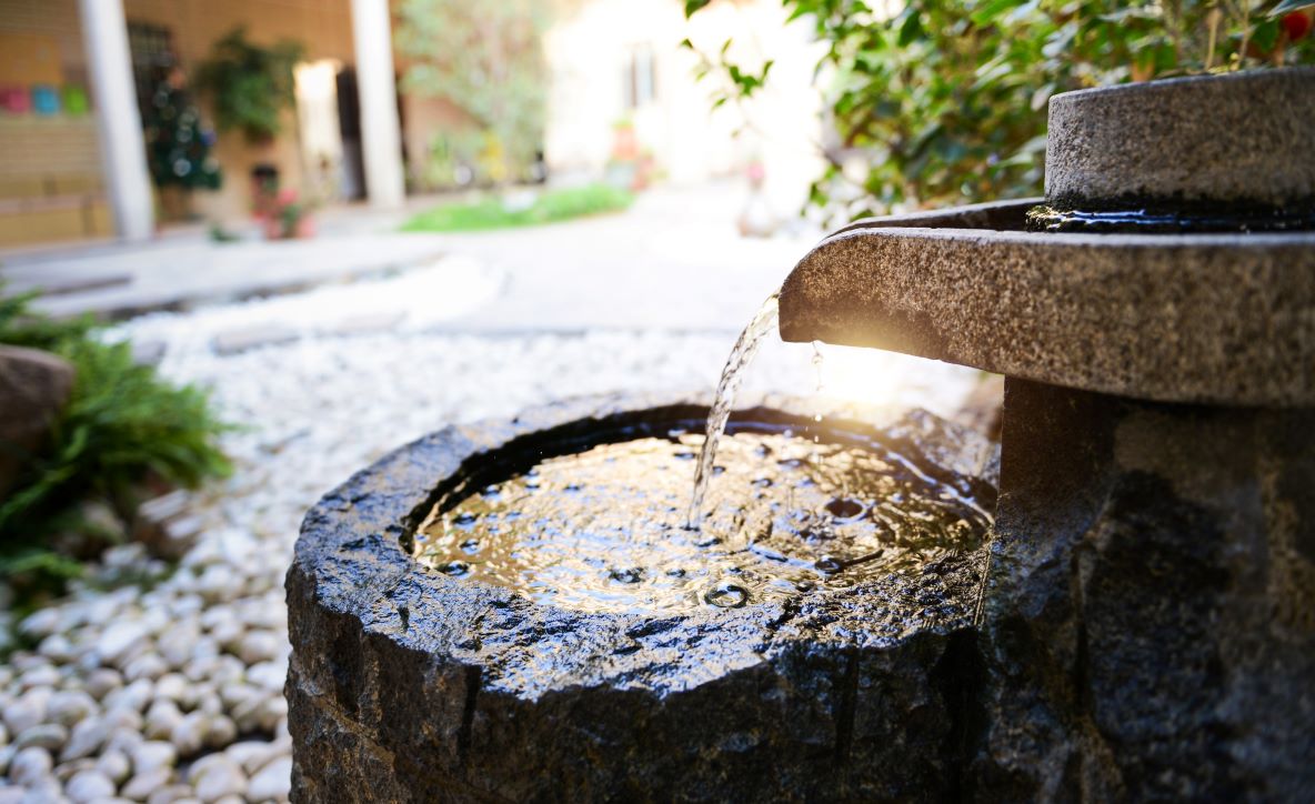 A stone fountain in a garden.