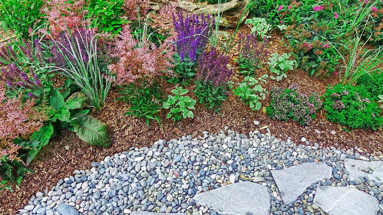 flower garden with mulch and decorative stones