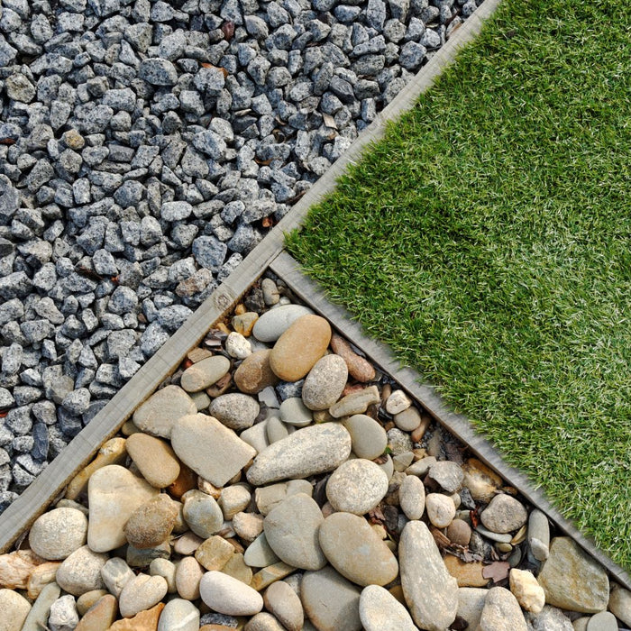 Three pieces of landscaping in one image: shale rocks, river rocks, and grass