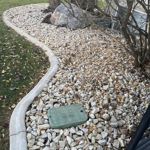 Green cover on rocks with grass and a house in the background