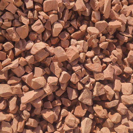 A close-up pile of Cherokee crushed stone - a small reddish-brown gravel or stone chips with rough, angular pieces